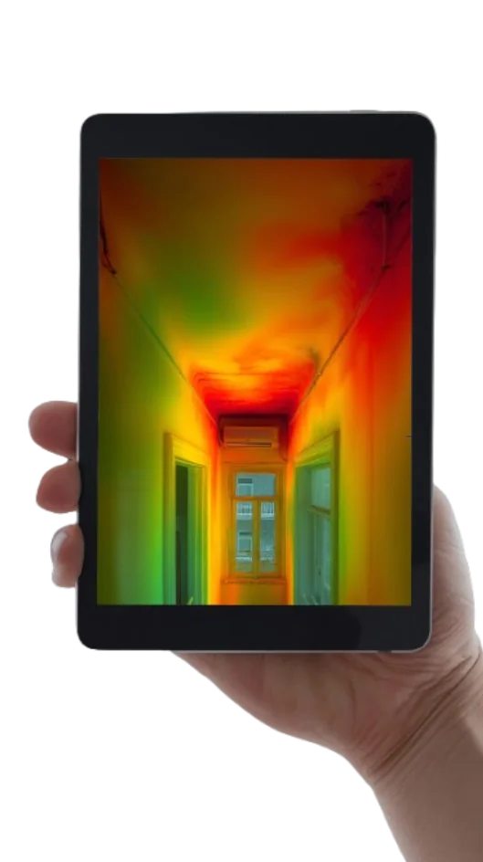 Hand holding a tablet showing a thermal image of a home interior with heat leaks at the ceiling
